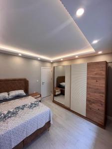 - une chambre avec un lit et un grand miroir dans l'établissement SÜPER KONUMDA LUX,ŞÖMİNELİ TASARIM DAİRE, à Istanbul