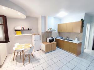 a kitchen with a table and a sink and a refrigerator at Palmeira Studio in Preveza