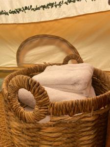 a basket with towels in it on the floor at Hollington Park Glamping in Newbury