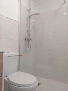 a white bathroom with a toilet and a shower at MAREZIA in Corralejo