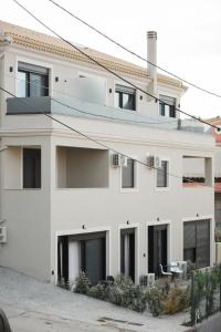 a white house with black windows at Serenity Suites Corfu in Potamós