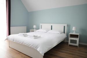 a bedroom with a large white bed with blue walls at Casa Doris in Sovata
