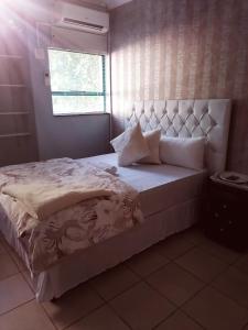 um quarto com uma cama grande e uma cabeceira branca em 66 Anglers Rod Guesthouse em Richards Bay