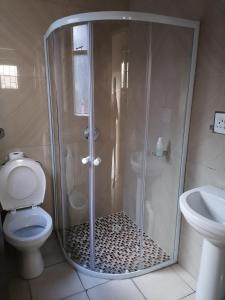 uma casa de banho com um chuveiro, um WC e um lavatório. em 66 Anglers Rod Guesthouse em Richards Bay