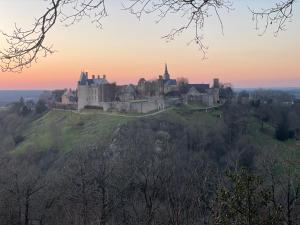 a castle on top of a hill at sunset at Coté jardin in Sainte-Suzanne