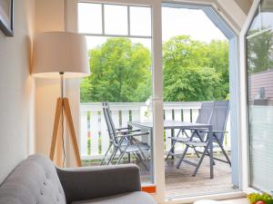 a living room with a table and chairs on a balcony at Haus Auguste - App. 16 in Bansin