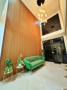 a green couch in a lobby with a wooden wall at Verra Inn in Tagaytay