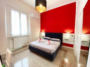 um quarto com uma cama com uma parede vermelha em Casa Granatelli em Palermo