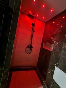 La salle de bains est pourvue d'une douche avec une lumière rouge. dans l'établissement Apt moderne en plein centre-ville, à Saint-Claude