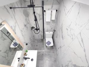 a bathroom with white marble walls and a shower at Palmeira Studio in Preveza