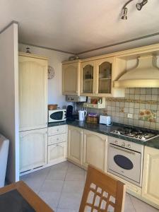 una cucina con elettrodomestici bianchi e armadietti in legno di Bel appartement proche Monaco a Beausoleil