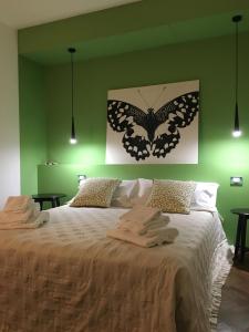 una camera da letto con un grande letto con un dipinto a farfalla sul muro di Casa B&B Fontanelle a Iseo