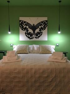 una camera da letto con un grande letto con un dipinto a farfalla sul muro di Casa B&B Fontanelle a Iseo