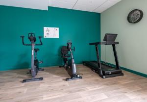 um quarto com três bicicletas de exercício e uma parede verde em DOMITYS L'HOROLOGIA em Cluses