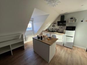 a kitchen with white appliances and a staircase at STUDIO SCANDINAVE - HYPER CENTRE LORIENT in Lorient