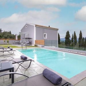 a swimming pool in front of a house at Summer Moments Pool Villa in Evropoúloi