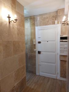 a bathroom with a shower and a white door at La Chambre des Sorciers in Blois