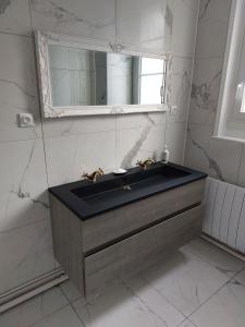 a bathroom with a sink and a mirror at La Chambre des Sorciers in Blois