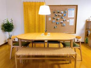 a dining room table with chairs and a lamp at LuLu Stay in Wakkanai