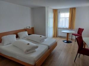 a bedroom with a bed and a table and a chair at Landgasthof Seelust in Egnach