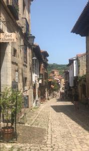 een geplaveide straat in een stad met gebouwen bij Hotel Altamira in Santillana del Mar