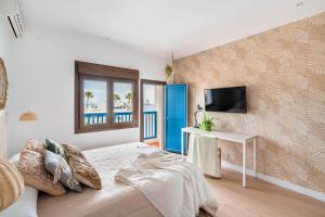 sypialnia z łóżkiem, stołem i telewizorem w obiekcie BF Rooms Carboneras w mieście Carboneras