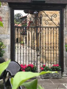 an iron gate with flowers in front of a building at Hotel Altamira in Santillana del Mar