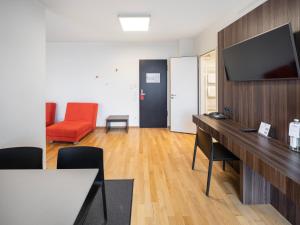 海德堡的住宿－博丁哈斯7天酒店，办公室,带桌子、电视和红椅