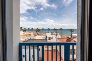 a balcony with a view of the ocean and palm trees at BF Rooms Carboneras in Carboneras