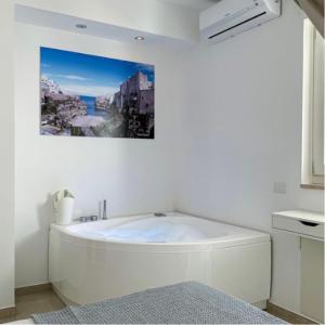 La salle de bains blanche est pourvue d'une baignoire. dans l'établissement SUITE CALA PAURA, à Polignano a Mare
