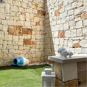 a room with a brick wall and a table with a water fountain at SUITE CALA PAURA in Polignano a Mare