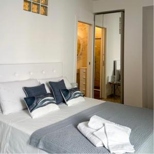 a bed with blue and white pillows on it at SUITE CALA PAURA in Polignano a Mare