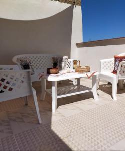 a white table and two white chairs and a table at AFFITTACAMERE LE SIGNORINE in Castellammare del Golfo