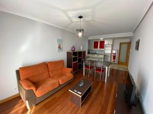 dpCristal LikeHome في ساريا: غرفة معيشة مع أريكة برتقالية ومطبخ
