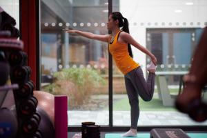 a woman doing a yoga pose in front of a window at For Students Only Chapter Old Street in London in London