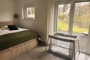 ein Schlafzimmer mit einem Bett und einem großen Fenster in der Unterkunft The Forest Retreat- Luxuriöse Ferienwohnung mit privater Sauna in Wermelskirchen
