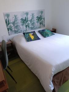 1 dormitorio con 1 cama blanca y 2 almohadas en HOTEL DE FRANCE, en La Tour-du-Pin
