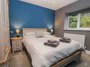 a bedroom with a large bed with towels on it at Quarry House,Chic and Quirky 3 Storey Home, Lake Access in Bowness-on-Windermere