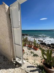 an open door in the side of a wall with plants at Villa sul Mare in Siracusa