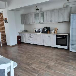 a kitchen with white cabinets and a tile floor at Andrana in Caciulata