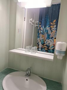y baño con lavabo y espejo. en HOTEL DE FRANCE, en La Tour-du-Pin
