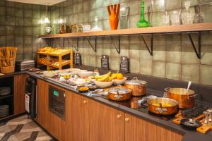 - une cuisine avec un comptoir pourvu de nombreux casseroles et poêles dans l'établissement Le Splendid Hotel Lac D'Annecy - Handwritten Collection, à Annecy