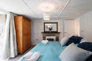 a bedroom with a large bed and a fireplace at Spacious flat St Ives former farmhouse, parking in St Ives