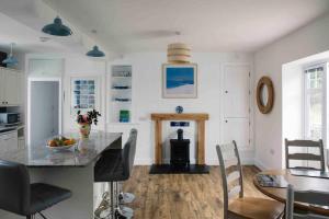 a kitchen with a counter and a table and chairs at Spacious flat St Ives former farmhouse, parking in St Ives