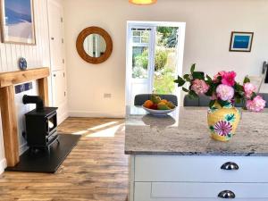 a kitchen with a counter with a vase of flowers at Spacious flat St Ives former farmhouse, parking in St Ives