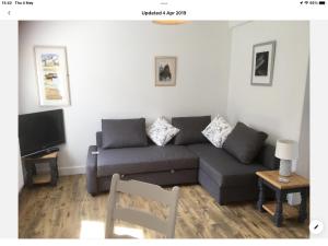 a living room with a couch and a tv at Spacious flat St Ives former farmhouse, parking in St Ives +21 photos