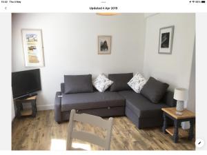 a living room with a couch and a tv at Spacious flat St Ives former farmhouse, parking in St Ives