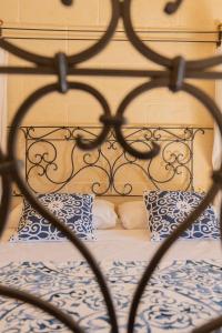Una cama de metal con almohadas azules y blancas. en Razzett Ziffa en Victoria