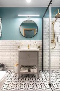 uma casa de banho com um lavatório e um espelho em Mary&Arte Apartments Grzegórzecka 15 em Cracóvia
