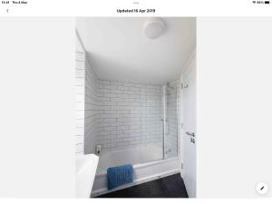a white bathroom with a tub and a shower at Spacious flat St Ives former farmhouse, parking in St Ives